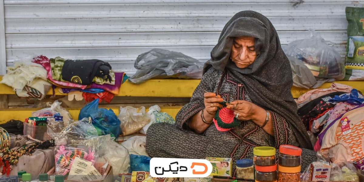 بازار بلوکان چابهار، تصویر یک مادربزرگ (بلوک) بلوچ در حال فروش صنایع دستی و ادویه‌جات رنگارنگ محلی.